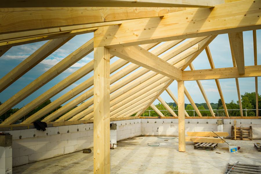 Charpente en bois clair d'une toiture en construction, vue de l'intérieur sous les chevrons