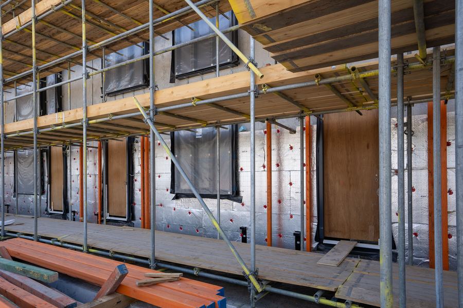 Échafaudage devant la façade d'un immeuble dont les murs reçoivent des panneaux isolants